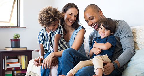 family laughing on a couch